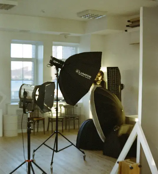 A professional photography studio setup featuring lighting equipment and reflectors.