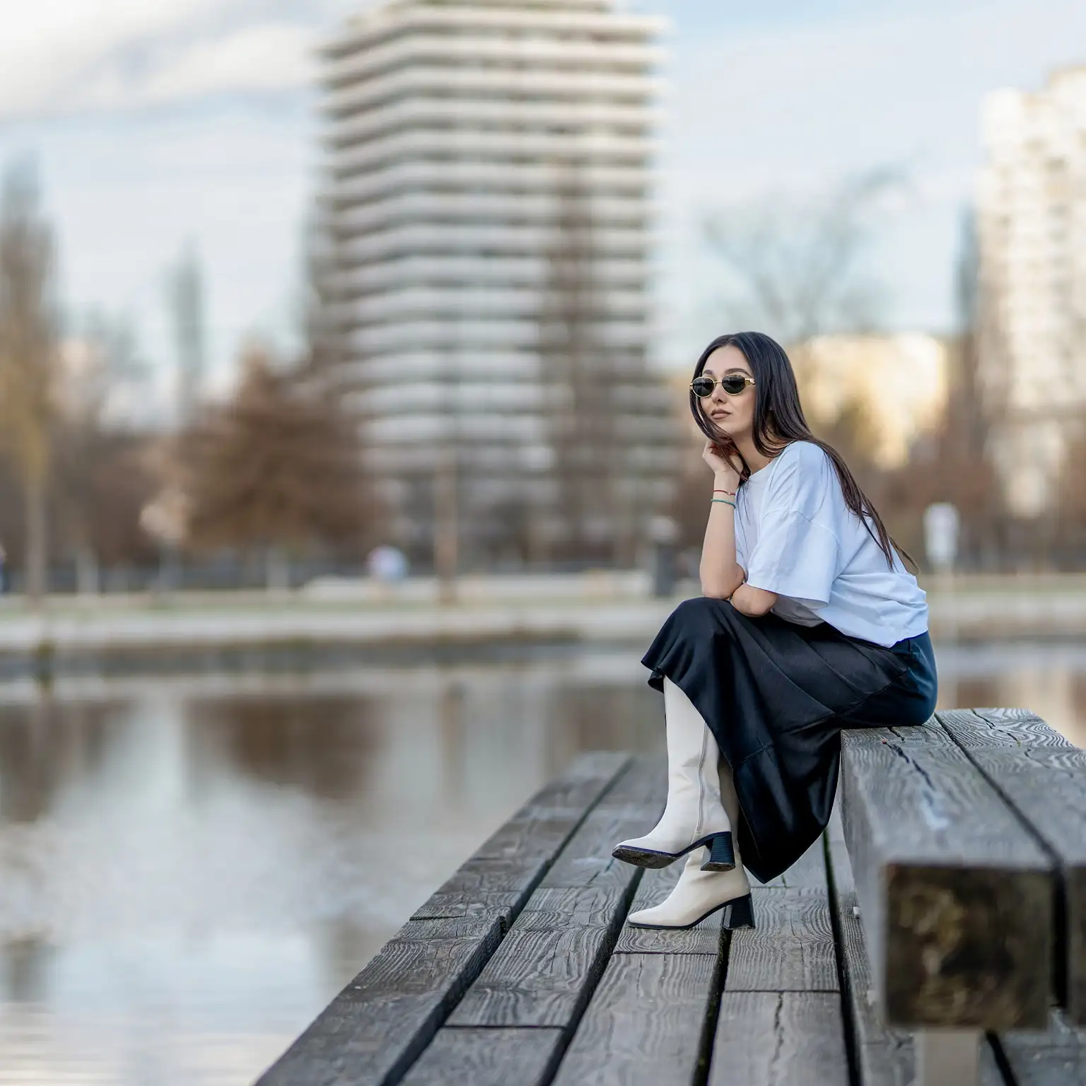 A woman relaxing by the lakeside, enjoying the serene environment.