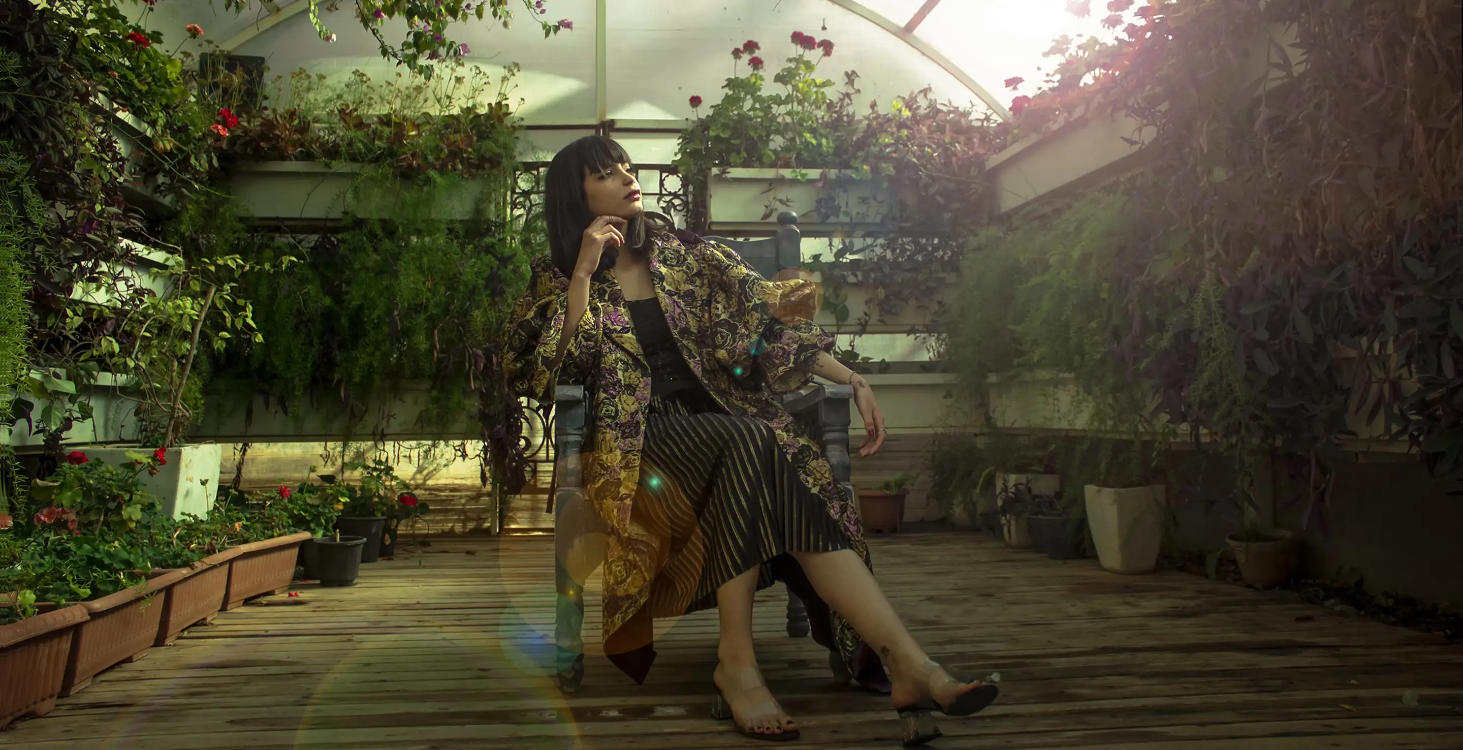 A serene portrait of a woman in a garden, highlighting her elegant attire and the surrounding flora.