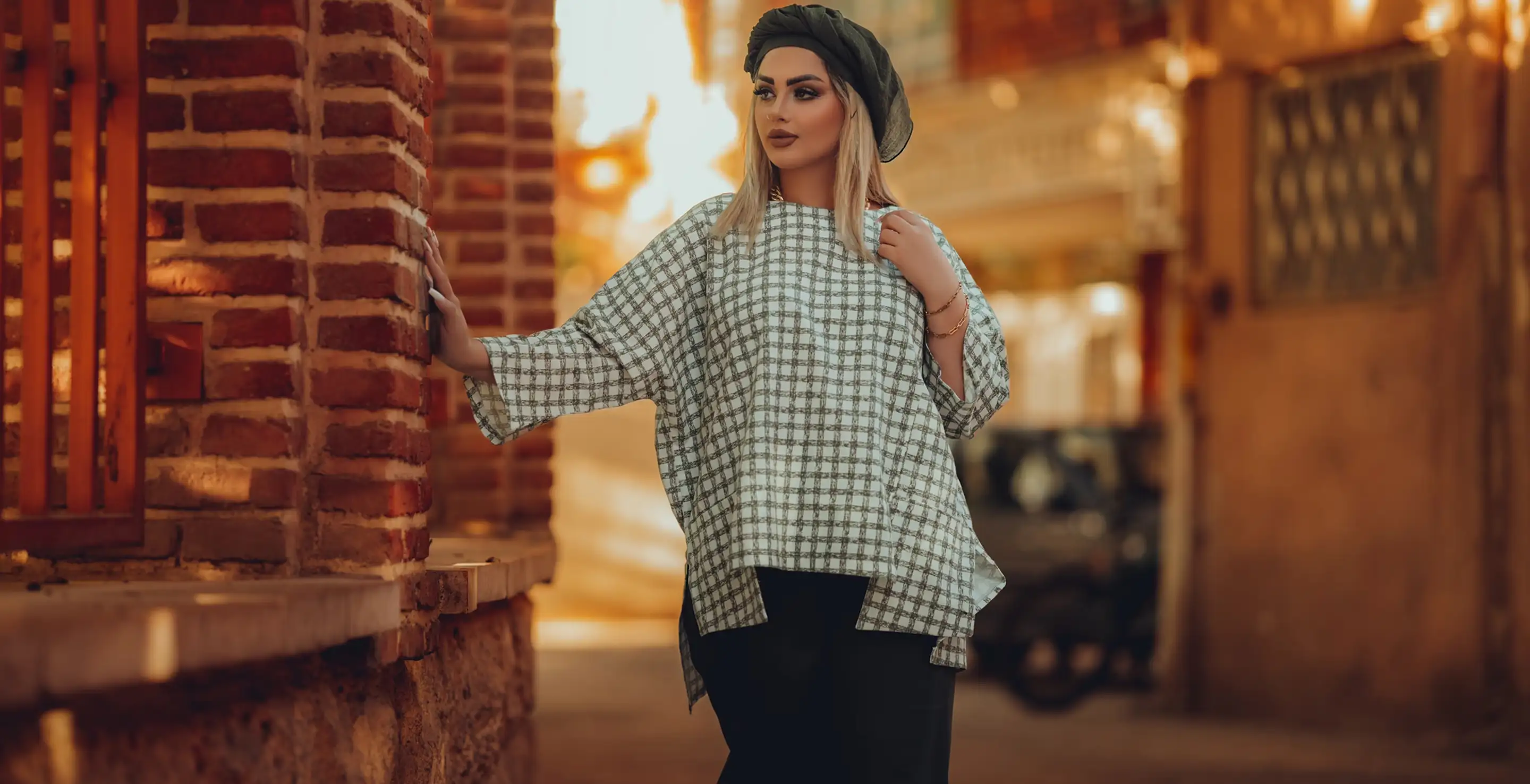 Portrait of a woman in urban fashion, showcasing a checkered top and a headscarf.